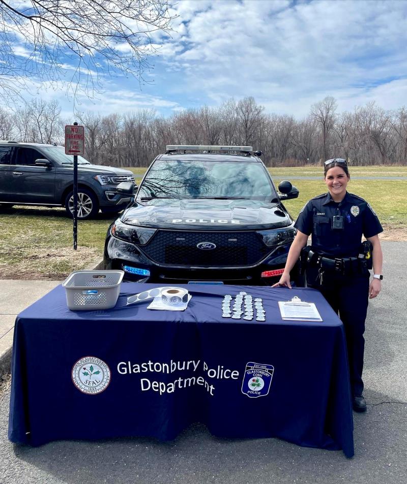 Photo of Community Outreach Officer in front of her Police car